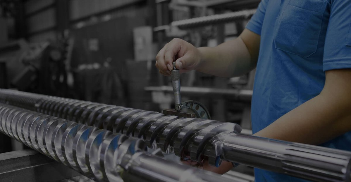 Technician measuring a TwinScrew extruder screw against its design tolerances